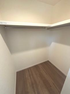 【収納】 | 東広島市高屋町高屋堀（全2区画）1号棟 | 主寝室に隣接する大容量のウォークインクローゼット。ハンガーパイプと上部棚が設置されており、衣類から季節物の家電、旅行カバンまで一括して収納可能です。整理整頓が捗り、生活空間を広く活用できます。