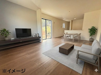 【居間・リビング】 | 東広島市高屋町高屋堀（全2区画）1号棟 | 壁一面に設えられたスタイリッシュな造作TVボード。周辺機器をすっきりと収納できるだけでなく、空間のアクセントとしても機能します。大きな掃き出し窓からは自然光がたっぷりと差し込み、開放感も十分です。