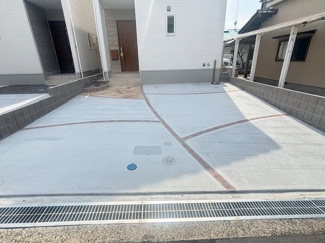 【駐車場】 | カーサ・ヴェルディ峰高2丁目　全2区画　NO1 | コンクリート敷きで整えられた、フラットなカースペースです。ライン状の装飾がアクセントになっています。道路からの高低差が少なく、運転が苦手な方でも入出庫が行いやすい設計です。