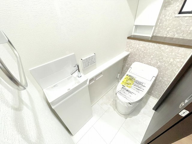 【トイレ】 | 入間郡三芳町藤久保　新築一戸建住宅　全1棟　(ふじみ野店) | 1階トイレ：タオル掛け、カウンターや洗面付きの便利なトイレ。人間センサーや温水洗浄便座機能もございます。