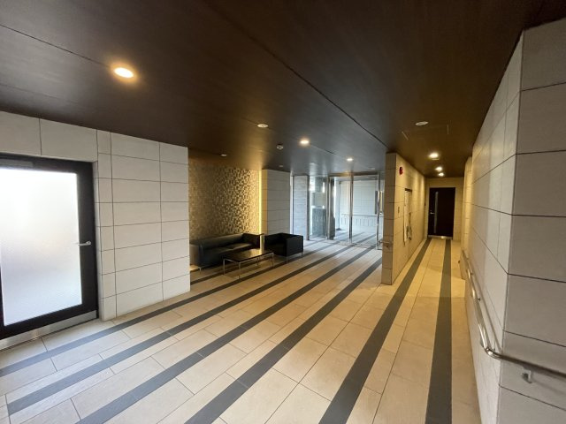 アルファステイツ野田Ⅲのその他共用部分|エントランスの写真になります。アースカラーと基調としてそこに黒と白の凹凸タイルを取り入れることでシックな仕上がりになっております。