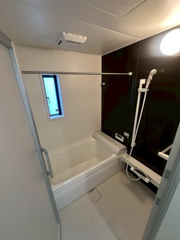 クレイドルガーデン宜野湾市上原 第２・２号棟の浴室|換気暖房乾燥機付きユニットバスで、物干し竿も備えた快適な浴室／浴室窓付き