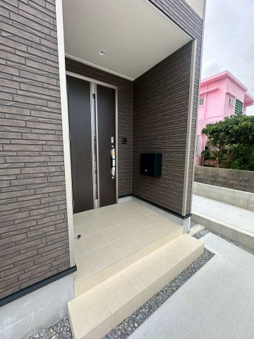 クレイドルガーデン宜野湾市上原 第２・２号棟の玄関|屋根付きで置き配スペースも確保できる玄関ポーチ／人感センサー付き玄関灯・TVモニター付きインターフォン・防犯カメラ◎