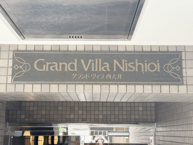 【現況写真】 | グランドヴィラ西大井 | エントランスに掲げられた、マンション名を示す館銘板。さほど激しく主張はしませんが、しっかりと掲示されています。～即日のご見学可能～　お問合せはお気軽にどうぞ。
