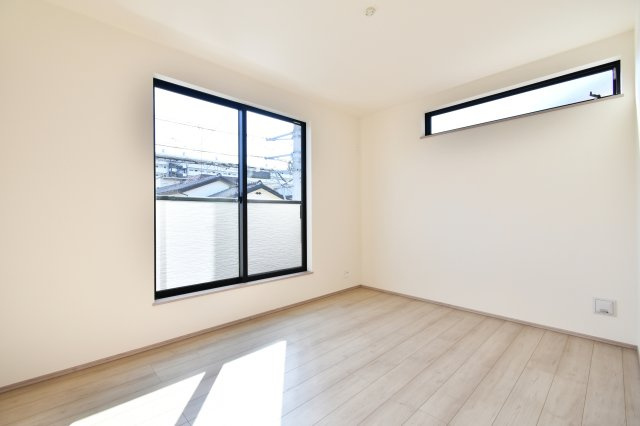 伊奈町栄四丁目76番　全1棟の洋室|洋室①：2面採光を実現した明るい約6帖の洋室。大きな窓からは陽光がたっぷりと降り注ぎ、開放感に満ちた空間を創出します。プライバシーを守るスリット窓の配置など、細やかな設計が光る心地よい主寝室です。
