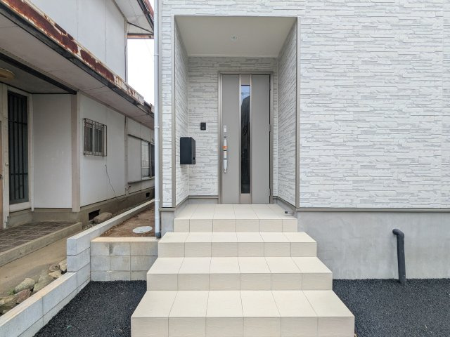 つくば市高見原　第18　新築戸建て　の玄関|玄関ドアはカードキーで開閉も楽々♪
スマホでの開錠と施錠も可能です！
玄関上部には人感センサー付きのダウンライトがあるので、夜間の帰宅時に自動で点灯してくれます♪
防犯対策面にも一役買ってくれます！