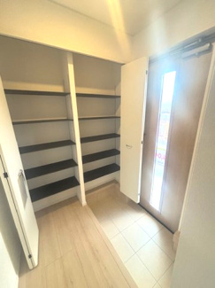 【玄関】 | 東広島市八本松飯田4丁目（全4区画）No１ | 可動棚を備えた大容量の玄関収納。靴だけでなく、ベビーカーやアウトドア用品もそのまま収まる土間仕様です。扉付きで来客時には視線を遮り、玄関周りをすっきりと保てます。