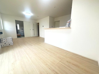 【居間・リビング】 | 東広島市八本松飯田4丁目（全4区画）No１ | キッチン側から見渡したリビング。隣接する和室の扉を開放することで、より奥行きのある空間として活用可能、白壁に木目調のフローリングを合わせたシンプルな内装は、お手持ちの家具とも調和しやすいデザインです。