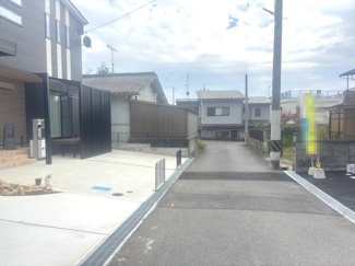 【前面道路含む現地写真】 | 東広島市西条町田口字小滝原（全1棟） | 高低差のない平坦な前面道路に面しており、スムーズな入出庫が可能です。周辺は落ち着いた住宅街で、視界を遮る大きな建物が少なく、開放感のある立地条件となっています。