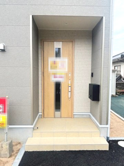 【玄関】 | 東広島市西条町田口字小滝原（全1棟） | 木目調の玄関ドアが温かみを添えるエントランス。軒先が深く設計されており、雨の日でも濡れずに鍵の開け閉めが可能です。タイル貼りのポーチは掃除がしやすく、清潔感を保ちやすい仕様です。
