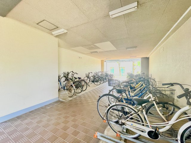 武庫川あおぞらのまち26号棟の駐輪場|サイクルラック付きの屋内駐輪場を設置。スッキリ整理されて、自転車同士が接触・転倒しにくい設計です。