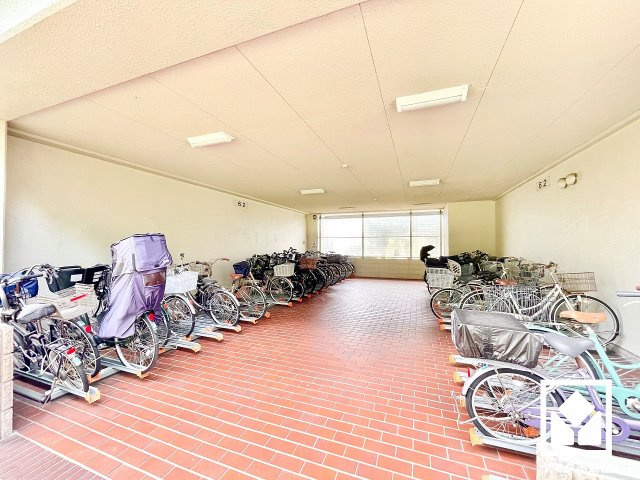 武庫川あおぞらのまち26号棟の駐輪場|サイクルラック付きの屋内駐輪場を設置。スッキリ整理されて、自転車同士が接触・転倒しにくい設計です。