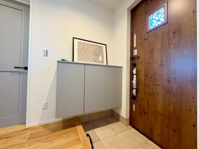 南国市大そね甲B号地　平屋新築一戸建ての玄関|木の玄関ドアが映える空間。収納付きでスッキリ整う玄関まわり