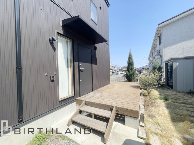 大槻町小山田　BESS施工の中古戸建て の外観|玄関側から続くウッドデッキはリビング側へL字に広がっています。