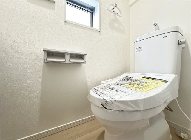 【トイレ】 | 朝霞市宮戸4丁目　新築一戸建住宅　全1棟　(丸井志木店) | トイレは家族を感染症から守る温水洗浄便座を完備。
衛生用品や掃除グッズなどの保管に便利な壁面収納付きです。
