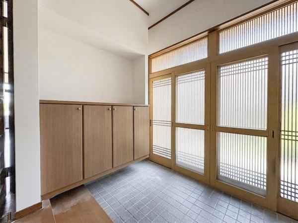 上宗方　中古の玄関|格子の開き戸が印象的な明るい玄関。収納付きで玄関まわりをすっきり保てる、落ち着きのある空間です。