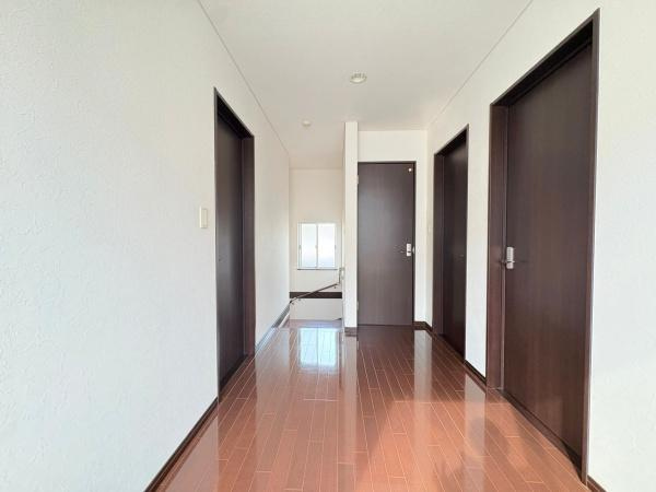 望みが丘　戸建ての内装|明るく開放感のあるフリースペースが印象的です。各部屋へのアクセスがしやすい配置となっています。光が差し込む空間で落ち着いた色合いのドアも特徴的です。