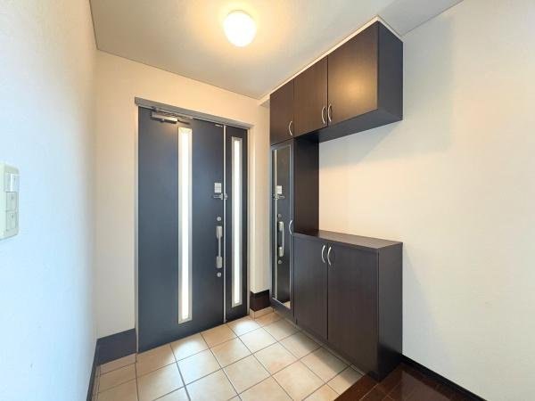 望みが丘　戸建ての玄関|玄関は明るい照明と広々とした空間が特徴です。大容量の収納があり荷物の整理整頓にも便利です。ダブルドアで使い勝手の良さも感じられます。