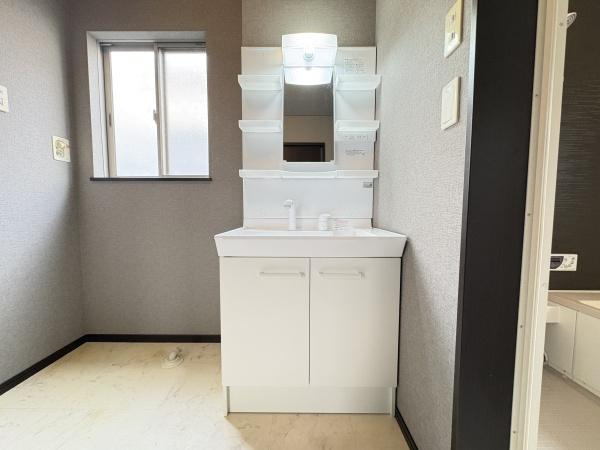 望みが丘　戸建ての独立洗面台|収納棚が複数設けられた洗面台で日用品を整理しやすい設計です。窓付きで自然光が入り明るい空間が広がっています。清潔感のあるホワイトを基調としお手入れがしやすいデザインです。
