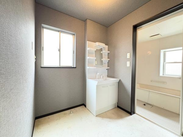 望みが丘　戸建ての独立洗面台|窓から自然光が差し込む洗面所です。シンプルなデザインの洗面台が設置されています。隣接する浴室との動線も快適です。使いやすさに配慮された空間となっています。