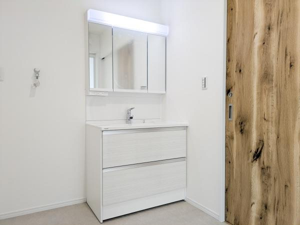 P-TELAS横田2丁目の独立洗面台|清潔感のある洗面台は白を基調としたデザインで空間が明るく見えます。鏡は大きく毎日の身支度にも使いやすい仕様です。収納スペースも備わっているので物がすっきりと整理できます。