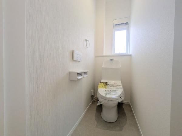 P-TELAS横田2丁目のトイレ|明るい採光のあるトイレです。シンプルで清潔感のある内装が印象的です。壁リモコンや収納スペースも備わっています。ゆったりとした空間設計です。