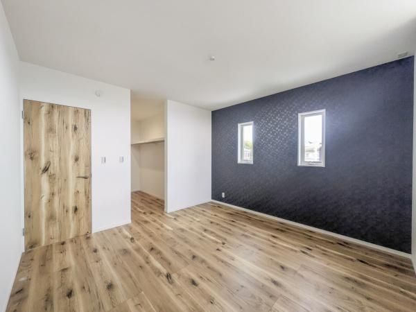 P-TELAS横田2丁目の洋室|フローリングのデザインが印象的な洋室です。ダークトーンのアクセントクロスが落ち着いた雰囲気を演出しています。窓からの採光で明るさもあります。収納スペースも確保されています。