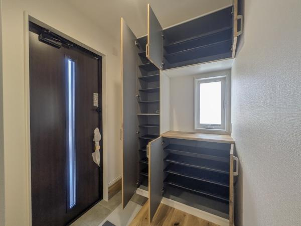 P-TELAS横田2丁目の玄関|玄関には収納スペースが充実しており靴や小物の整理がしやすいです。小窓から自然光が入り明るさを感じられます。開閉しやすい扉で日々のお出かけをサポートします。