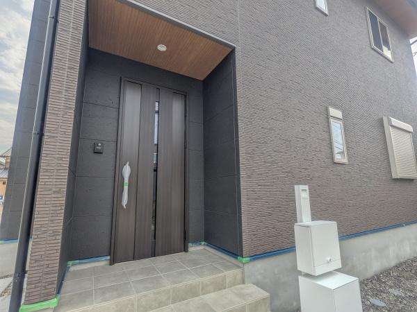 P-TELAS横田2丁目の玄関|落ち着いた色合いの玄関が住まい全体に品のある印象を与えています。使いやすい広さのタイル式アプローチが魅力です。すっきりとしたデザインの玄関ドアが外観と調和しています。