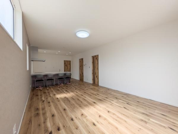 P-TELAS横田2丁目の居間・リビング|リビングは広々とした空間が広がり窓から自然光がしっかり届きます。ナチュラルな木目調のフローリングが印象的です。シンプルな内装でお好みに合わせたレイアウトが楽しめます。