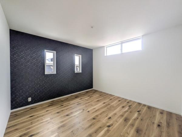 P-TELAS横田2丁目の洋室|洋室のアクセントクロスが空間に個性を与えています。2つの縦長窓から自然光が差し込み明るい印象です。天井まで広がる開放感のある室内です。木目調のフローリングが温かみを感じさせる洋室です。