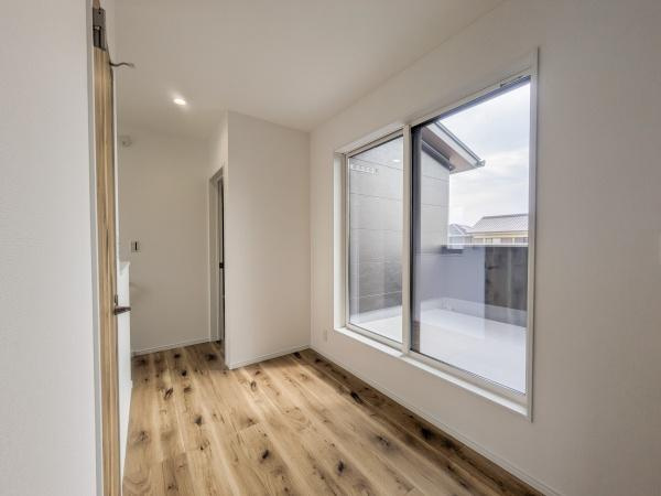 P-TELAS横田2丁目の内装|大きな窓から自然光がしっかり差し込み室内がとても明るい印象です。隣接するバルコニーも広々として使い勝手が良さそうです。ナチュラルな木目の床が空間に温かみを与えています。