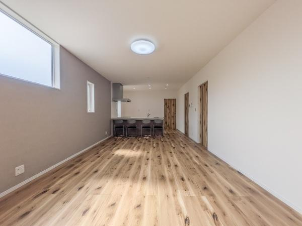 P-TELAS横田2丁目の居間・リビング|リビングは広々とした空間で縦長の間取りが開放感を演出しています。窓から差し込む光で室内が明るく保たれています。木目調のフローリングが落ち着いた雰囲気を与えています。