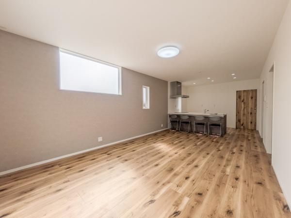 P-TELAS横田2丁目の居間・リビング|広々としたリビングが印象的です。窓から柔らかな光が差し込み明るい空間を演出しています。木目調のフローリングが温かみを感じさせます。キッチンとの一体感も魅力のひとつです。収納スペースも確保されています。