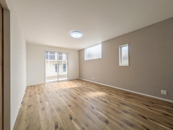 P-TELAS横田2丁目の居間・リビング|リビングは大きな窓から光が差し込み室内が明るさに包まれます。床材の質感が温かみを感じさせます。シンプルな壁面が家具のレイアウトをしやすい印象です。天井の照明が室内を均一に照らします。