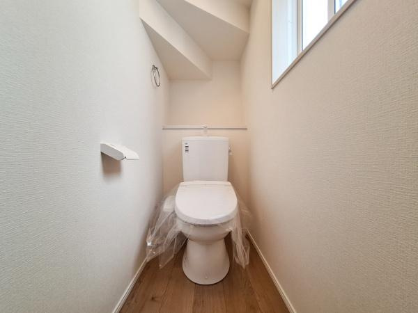 久原北1期1号棟のトイレ|窓があり明るい印象のトイレ空間です。シンプルで落ち着いた内装が特徴的です。床は木目調で清潔感があります。換気しやすい設計です。スペースの使い方が工夫されています。