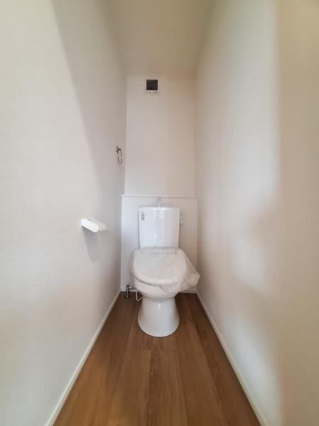 久原北1期1号棟のトイレ|窓があり明るい印象のトイレ空間です。シンプルで落ち着いた内装が特徴的です。床は木目調で清潔感があります。換気しやすい設計です。スペースの使い方が工夫されています。