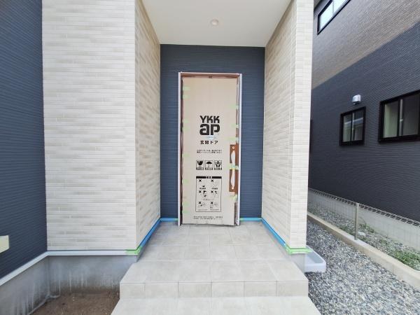 久原北1期1号棟の玄関|落ち着いた色合いのタイルと洗練された玄関ドアが調和しています。細部まで配慮された仕上がりが印象的です。スッキリとした空間が広がり日々の出入りも快適に感じられます。玄関スペースの使い勝手にも注目です。