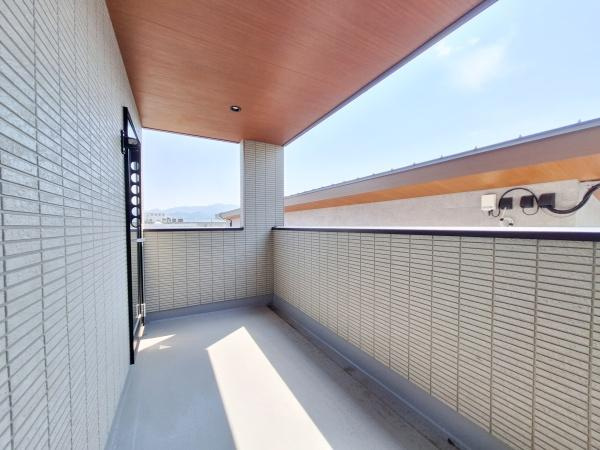 CASA BIANCA No.1のバルコニー|開放感のある広々としたバルコニーが魅力です。屋根付きで急な天候の変化にも安心です。壁面のタイル仕上げが落ち着いた雰囲気を演出します。