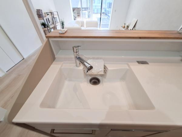 CASA BIANCA No.1のキッチン|キッチンシンクが広々としており作業がしやすい設計です。カウンター部分は物の置き場所としても活用できます。リビングと一体感のあるキッチン空間です。