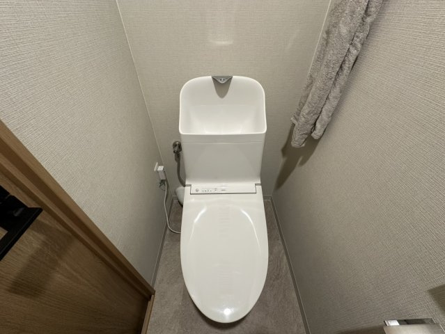 千里中央パーク・ヒルズE棟のトイレ|リフォーム済みのきれいなトイレです。ウォシュレット付き。開閉式の収納もあります。