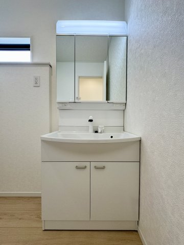 馬郡町 第1 2号棟の独立洗面台|三面鏡になっているシャワー付き洗面台で収納スペースも充実しています。