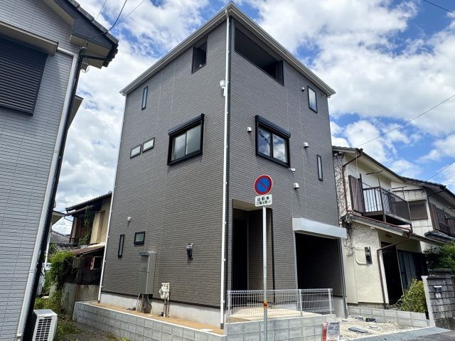 「2階リビングの３階建」高知市 旭町３丁目 3階建 新築一戸建の外観|8/7撮影。青空に映えるモダンで落ち着いたデザイン。前面駐車場で車の出し入れもラクラクです。