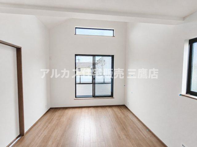 京王線 仙川駅 徒歩7分 新築戸建 調布市仙川町３丁目の居間・リビング|吹き抜け風の高い天井と上部窓が解放感を生み出す、明るく快適な空間。