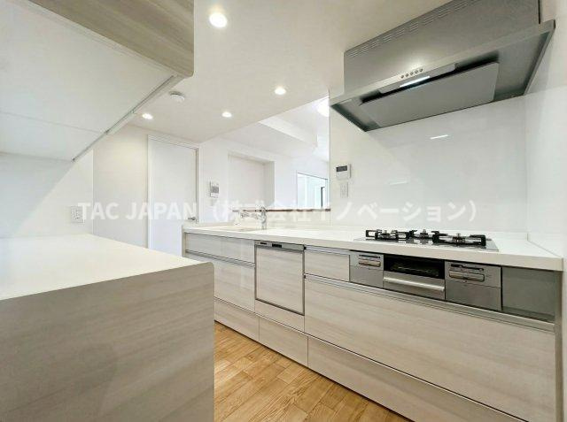 ネバーランド上野松が谷のキッチン|お料理の合間にも会話が楽しめる対面式のシステムキッチン。食事の時間がバラバラでも最後の人がスイッチONで洗い物が完結できるビルトイン食器洗浄乾燥機・便利な浄水シャワー栓・ガラストップ三口コンロを完備。