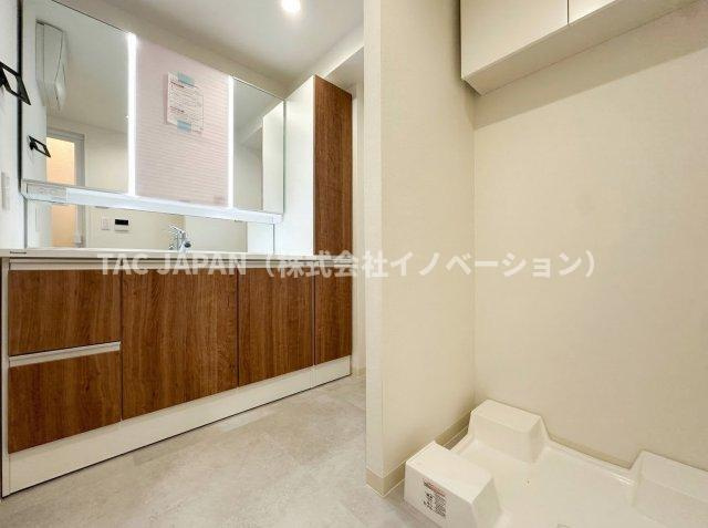 ネバーランド上野松が谷の洗面所|大型の洗濯機を置いても余裕が感じられる脱衣スペースにはお洒落な洗面ユニットを制作。着替えやタオル、洗剤の買い置きなどリネン庫の使い方はお客様しだい。