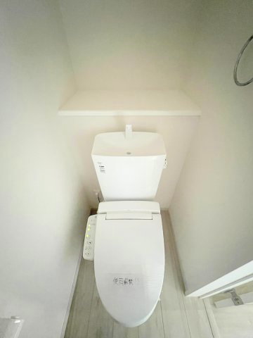 昭島市緑町5丁目　新築戸建全2棟のトイレ|1階温水シャワートイレ。小物やグリーンを飾れる便利なスペースが、上質で落ち着きのある空間を演出します。