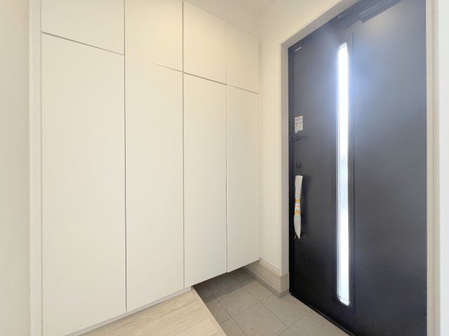 昭島市緑町5丁目　新築戸建全2棟の玄関|収納力のあるトールタイプのシューズボックスを採用。ご家族みんなの靴はもちろん、ブーツや小物までスッキリ収納でき、いつでもきれいな玄関を保てます。