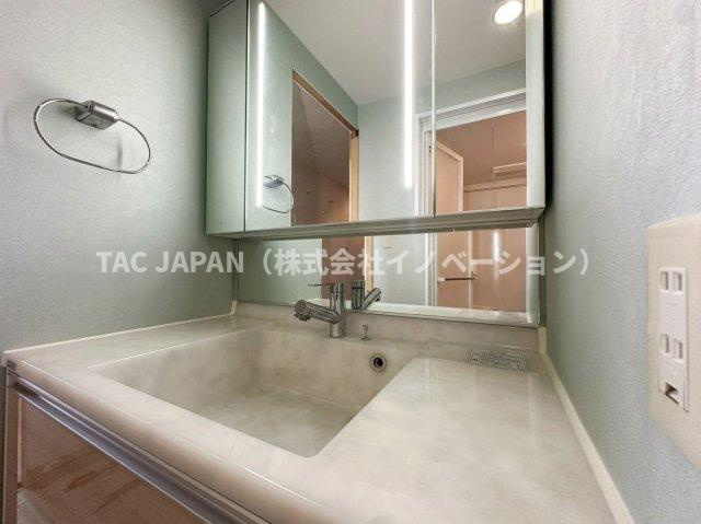 キャッスルマンション亀戸立花弐番館の洗面所|やわらかな色合いが上品な洗面化粧台。2024年交換の設備をリユースし、三面鏡収納付きで使い勝手も良好。清潔感があり、小物もすっきり収まり、ホテルライクな印象です。