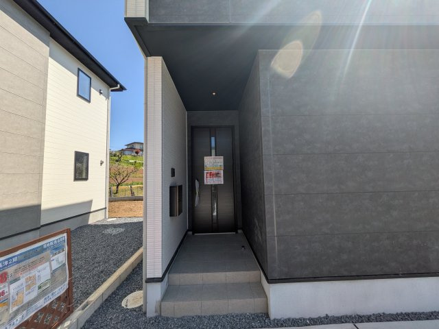 土浦市上高津2期　新築戸建て　5号棟の玄関|お洒落な玄関ドアと洗練された外壁デザイン。家の顔にふさわしい上質な佇まいで、ご家族やお客様を迎えます。